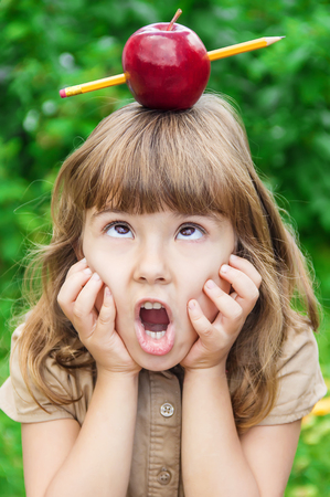 little girl student with a red apple. Selective focus. nature.の写真素材