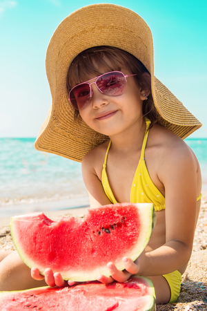 a child at sea eating a watermelon. selective focus. nature.の写真素材