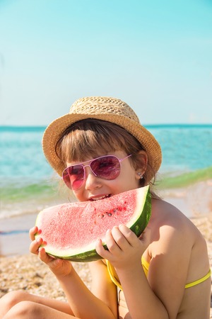a child at sea eating a watermelon. selective focus. nature.の写真素材