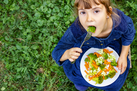 child eats vegetables. Summer photo. Selective focus natureの写真素材