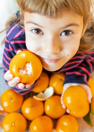 Child and tangerine. Selective focus. food and drink. natureの写真素材