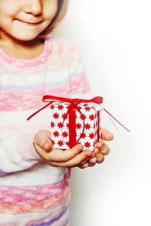 Child holds a Christmas decor and gifts on a white background. Selective focus. Happy.