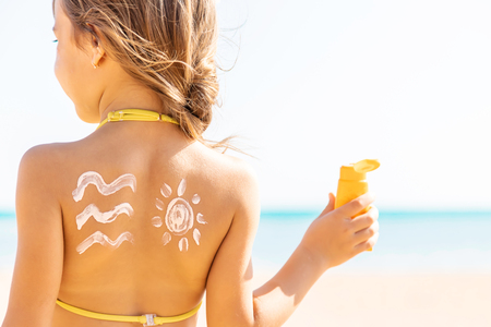 child on the beach smears sunscreen. Selective focus. People.の写真素材