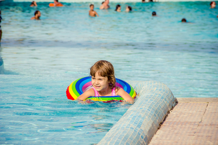 A child swims in a swimming pool with a life preserver. Selective focus.nature.の写真素材