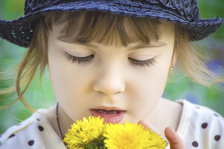 Girl, child, flowers dandelions in the spring plays. Selective focus.の写真素材