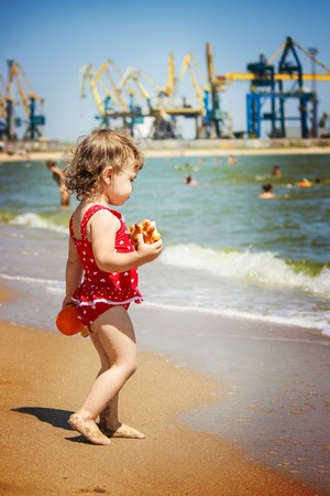 Baby girl on the beach, by the sea. Selective focus.の写真素材