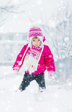 A child plays in the snow in the winter. Selective focus.の写真素材
