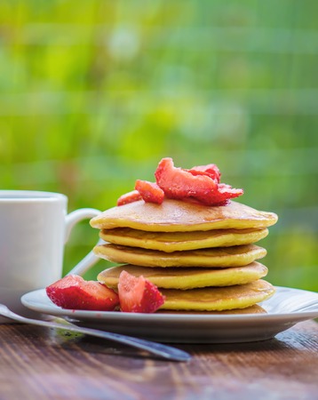 Pancakes tea and strawberry jam for breakfastの写真素材