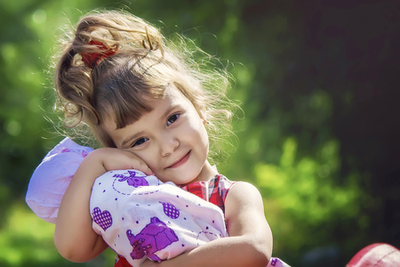 Girl with a doll. A game. Selective focus.の写真素材