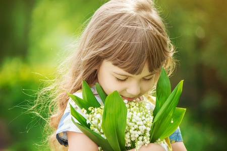 Girl with a bouquet of lilies of the valley. Selective focus.の写真素材