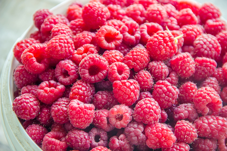 Raspberries are in the hands of a child in the form of a heart. nature.の写真素材