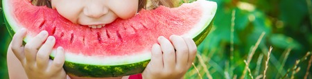 A child eats watermelon. Selective focus. Food natureの写真素材