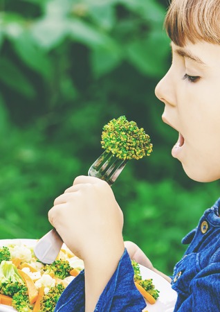 child eats vegetables. Summer photo. Selective focus natureの写真素材