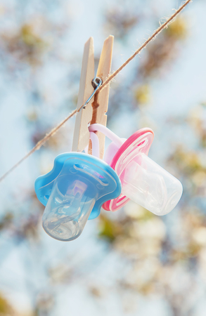 Baby clothes and accessories weigh on the rope after washing in the open air. Selective focus....