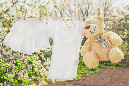 Baby clothes and accessories weigh on the rope after washing in the open air. Selective focus. nature.の写真素材