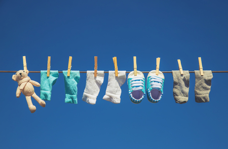 Baby clothes and accessories weigh on the rope after washing in the open air. Selective focus. nature.の写真素材