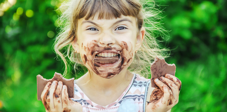 A sweet-toothed child eats chocolate. Selective focus. nature.の写真素材