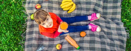 Child on a picnic with juice and fruit. Selective focus.の写真素材