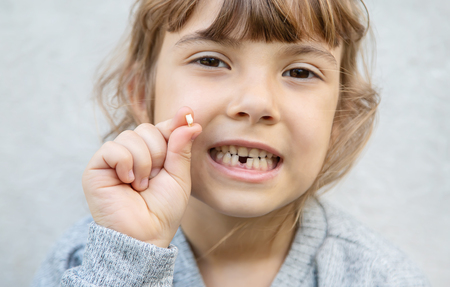 The kid had a baby tooth. Selective focus.
