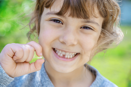 The kid had a baby tooth. Selective focus.