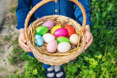Krashenki homemade eggs in the basket and the hands of a child. Selective focus. nature.
