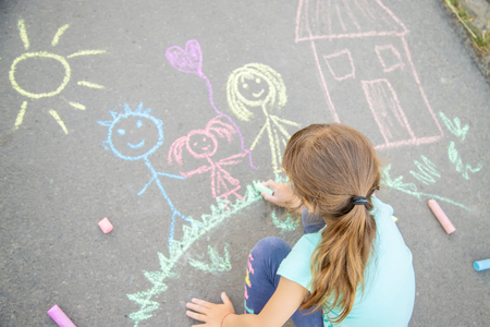 Child draws a family on the pavement with chalk. Selective focus. nature.