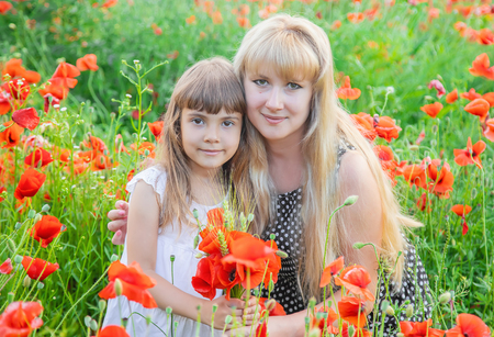 children girl in a field with poppies. selective focus.の写真素材