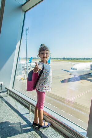 A child at the airport on the background of the aircraft. Selective focus.の写真素材