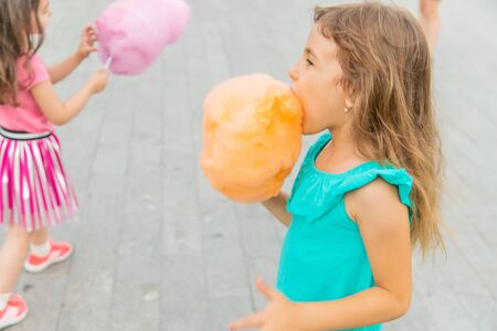 Children eat cotton candy in the park. Selective focus.の写真素材