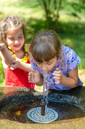 children drink water from a spring in Borjomi, Georgia. Selective focus.の写真素材