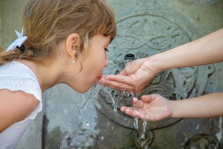 children drink water from a spring in Borjomi, Georgia. Selective focus.の写真素材