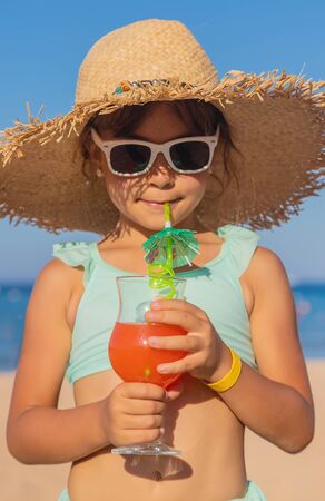 A child at the sea drinks a cocktail. Selective focus.の写真素材