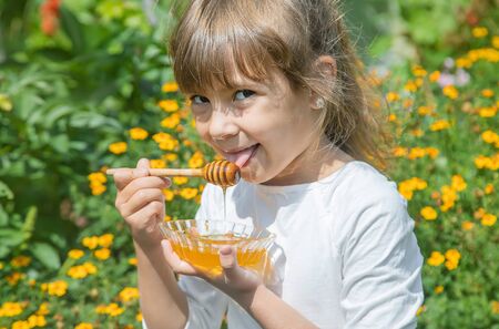 Child a plate of honey in the hands. Selective focus.の写真素材