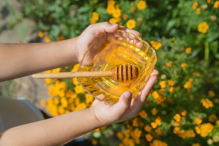Child a plate of honey in the hands. Selective focus. nature.の写真素材