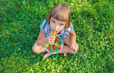 child eats vegetables broccoli and carrots. Selective focus.の写真素材