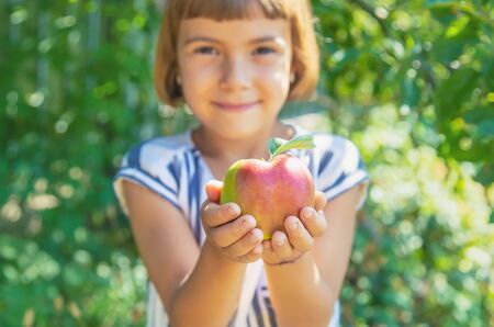 child with an apple in the garden. Selective focus.の写真素材