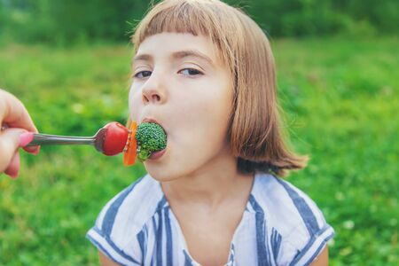 child eats vegetables broccoli and carrots. Selective focus.の写真素材