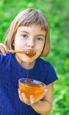 Child a plate of honey in the hands. Selective focus.の写真素材