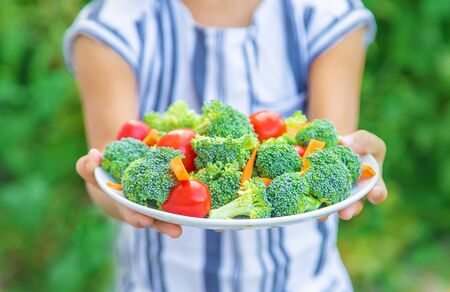 child eats vegetables broccoli and carrots. Selective focus. nature.の写真素材