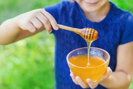 Child a plate of honey in the hands. Selective focus. nature.の写真素材