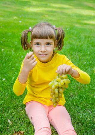 The child eats white grapes. Selective focus.の写真素材