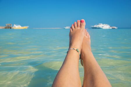legs of a girl on the seashore. Selective focus. nature.