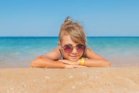 child lies in the sand on the beach. Selective focus.の写真素材