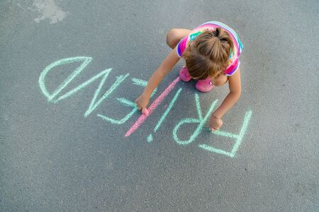Children's inscription on the asphalt with chalk, friends. Selective focus.の写真素材