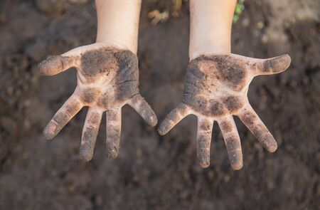 Child in the garden with the earth in his hands. Selective focus. nature.