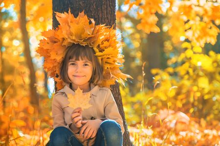 Children in the park with autumn leaves. Selective focus.