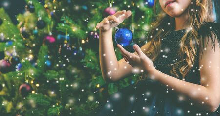 A family decorates a Christmas tree at night. Selective focus. Holiday.の写真素材