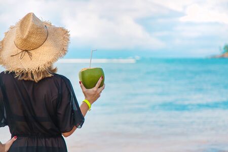 Girl on the beach drinks coconut. Selective focus. nature.の写真素材