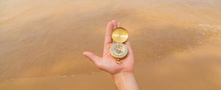 Compass on the background of the sea and the beach. Selective focus. travel.