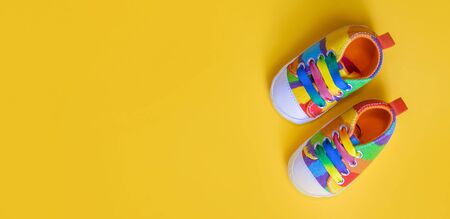 Shoes for newborns on a yellow background. Selective focus. Baby.の写真素材